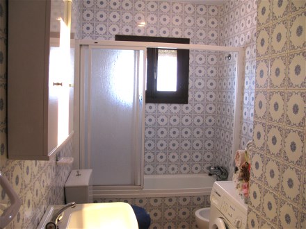 The bath room has a bath tube and a washing machine