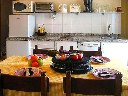 Neben der Kchenzeile steht ein groer Esstisch