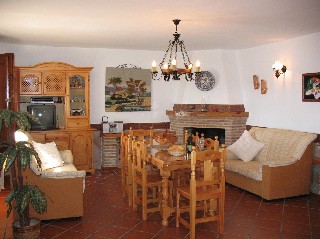 Das Wohnzimmer hat einen Esstisch und 2 Couchen.