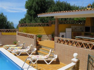 Am Pool gibt es eine berdachte Grillecke mit Esstisch