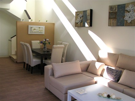 Im lichtdurchflutetetn Wohnzimmer gibt es neben der hellen Ledercouch eine Essecke