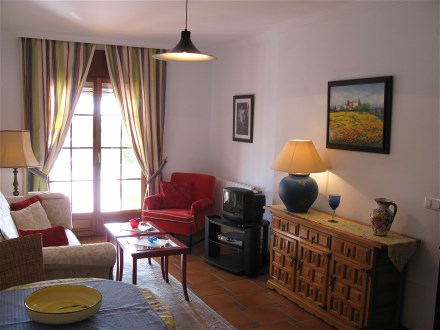 Das Wohnzimmer ist ansprechend eingerichtet mit heller Couch und Esstisch