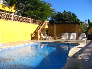 Neben dem ovalen Pool befindet sich eine Grillecke