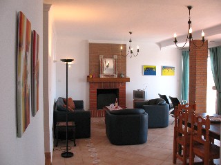 Im Wohnzimmer gibt es eine schwarze Couchgarnitur und einen grossen Esstisch