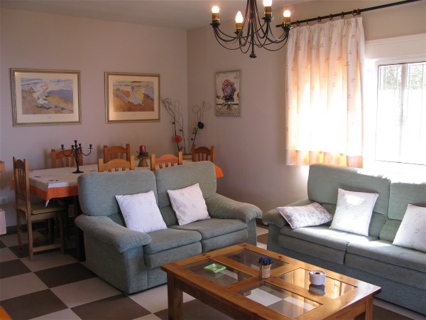 Das Wohnzimmer hat eine gemtliche Sitzecke und einen grossen Esstisch