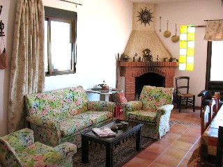 Im Wohnzimmer gibt es eine Sitzecke und einen offenen Kamin