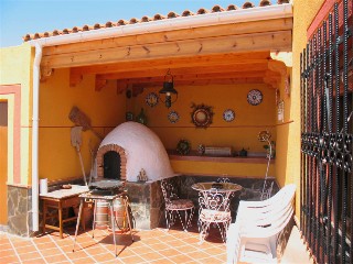 Neben dem Haus gibt es eine Grillecke mit Pizzaofen und Paella Pfanne