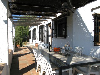 auf der berdachten Terrasse steht ein grosser Esstisch